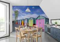 Beach wallpaper in a kitchen with a round wood table, cross back chairs and navy units GD13132