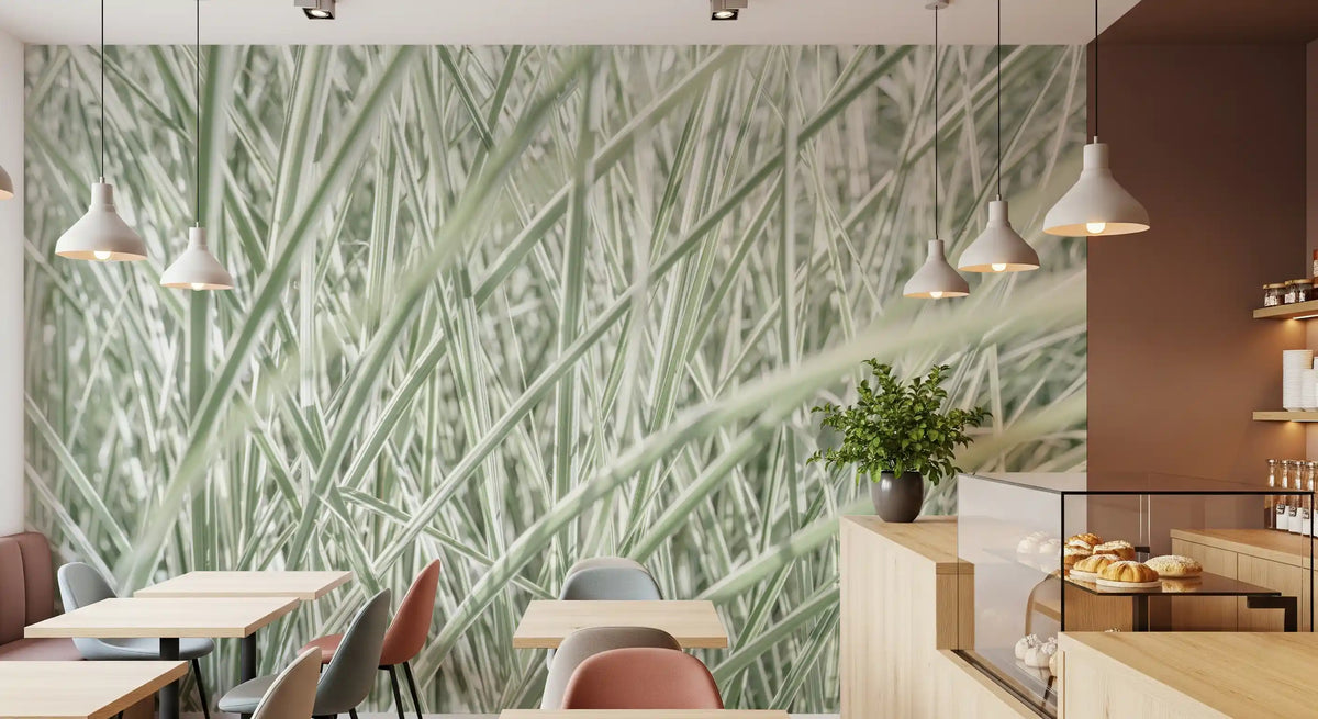 Sage grass wall mural in a cafe with pendant lights and pink chairs GD13142