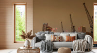 London wallpaper of dock cranes behind a grey sofa with orange cushions and a jute pouf GD13146