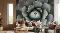 Gray agave wall mural behind a beige sofa with patterned cushions and slatted wood wall GD13148
