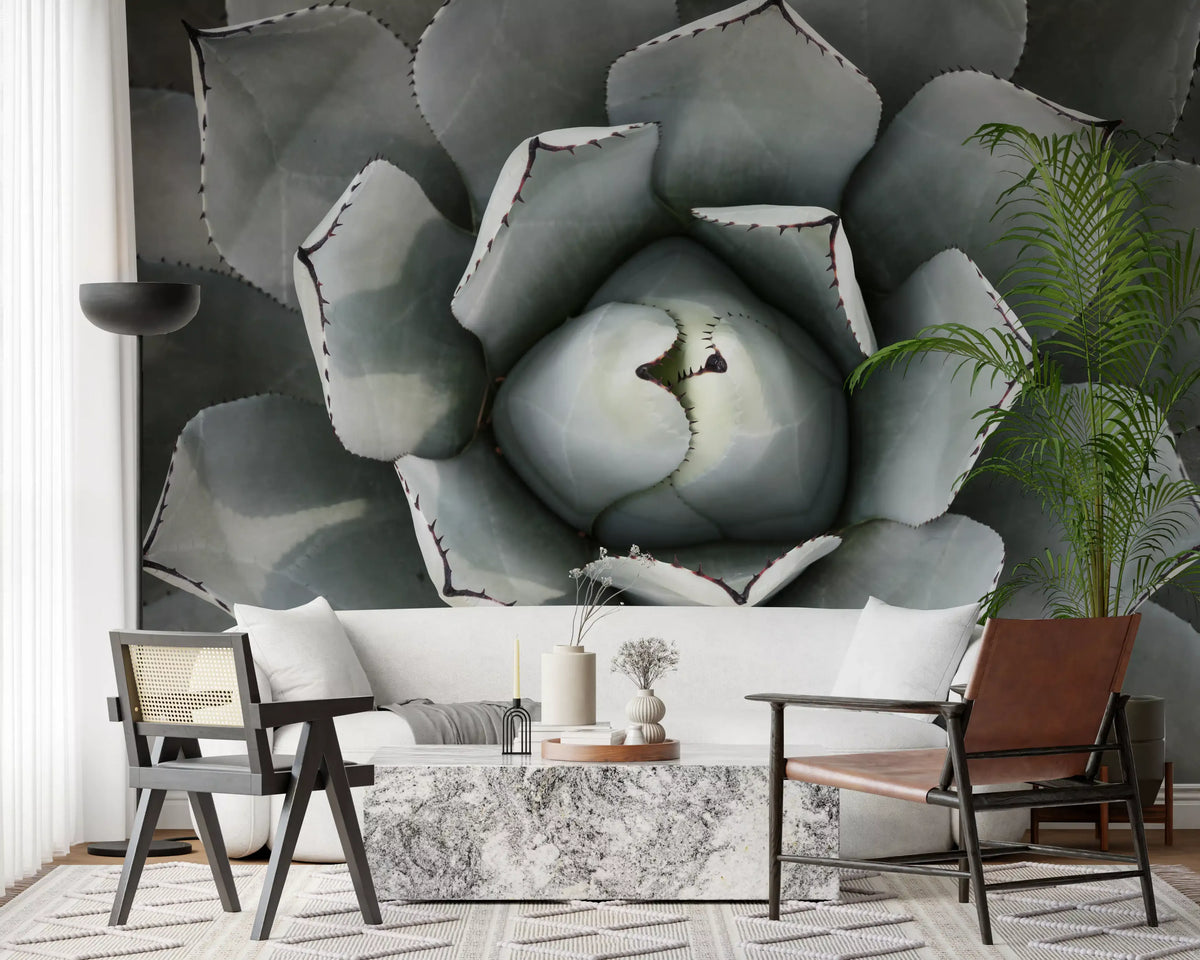 Botanical wallpaper of agave leaves behind a white sofa, leather chair and marble table GD13148
