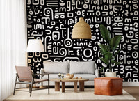 Monochrome geometrische Kritzel-Symbole auf schwarzem Wandbild