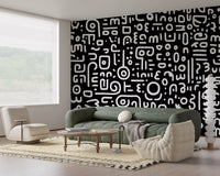 Monochrome geometrische Kritzel-Symbole auf schwarzem Wandbild