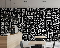 Monochrome geometrische Kritzel-Symbole auf schwarzem Wandbild