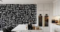 Monochrome geometrische Kritzel-Symbole auf schwarzem Wandbild