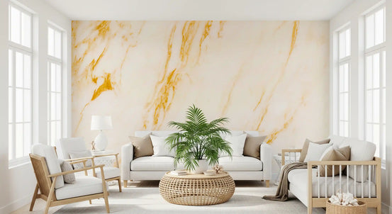 Marble wallpaper in ivory and gold behind a white sofa, rattan table and palm plant GD14114
