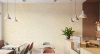Cafe with white pendant lights, small tables and pastry counter on a creamy stone wall GD14189
