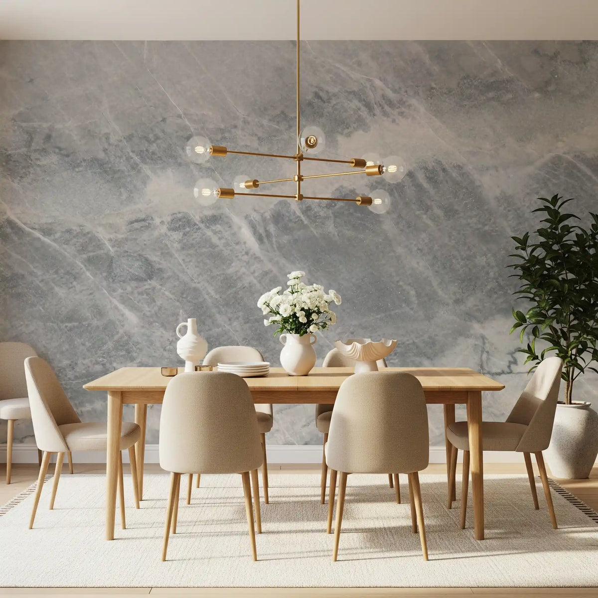 Dining room with an oak table and brass chandelier on a gray and cream marble wall GD14203