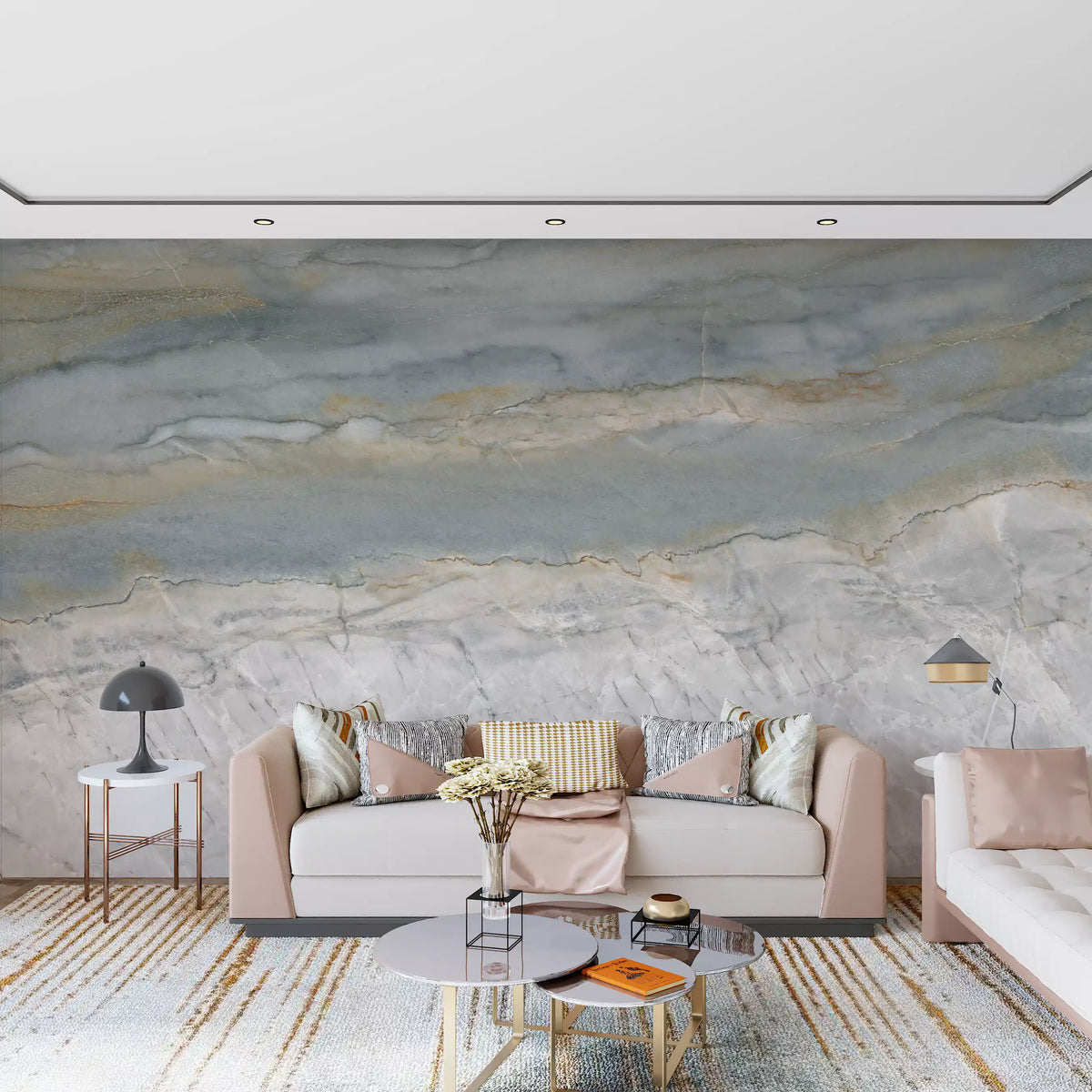 Blush pink sofa and gold striped rug in front of a gray and white marble wall GD14204