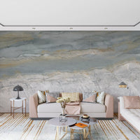 Blush pink sofa and gold striped rug in front of a gray and white marble wall GD14204