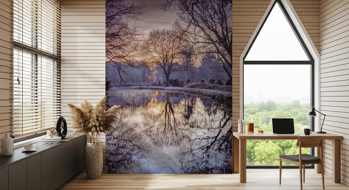 Vægmaleri med en gylden solnedgang, der spejler sig i skovens stille vand