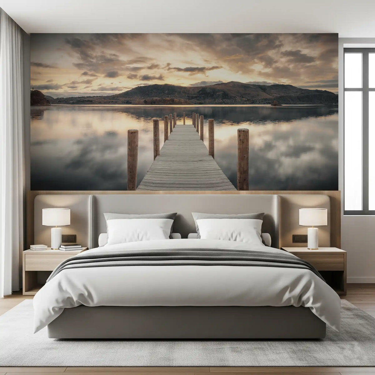 Bedroom with gray upholstered bed and white lamps against lake wallpaper of calm water GD14220
