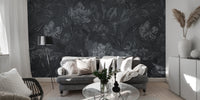 Black floral wallpaper mural installed on a living room feature wall, showing large, intricate white and pink blooms for a dramatic, luxurious effect.