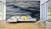 A contemporary living room with a large ocean wave wall mural.

