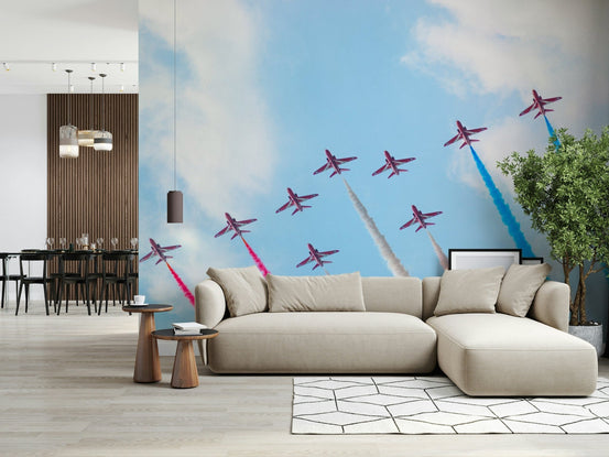 Air Show Spectacle wallpaper mural of red jets trailing colored smoke in a living room with a beige sectional sofa