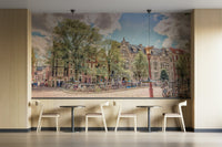 The image features classic European buildings and a large tree.

