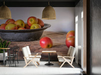 Wooden table with apples and bowl in cozy kitchen setting

