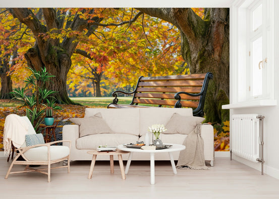 Autumn Serenity mural of a park bench under golden trees behind a cream sofa in a bright living room