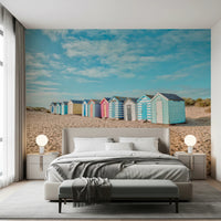 Soft pink and blue beach huts wall mural for bedroom on a sandy shore.
