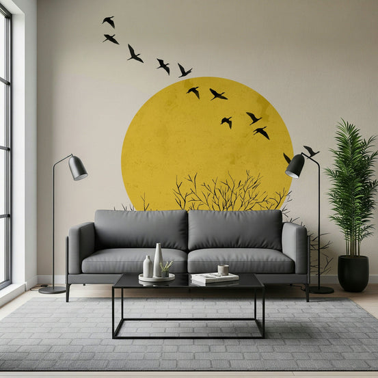 Birds at Sunrise wallpaper mural of a yellow sun and flying birds behind a grey sofa with black floor lamps in a living room