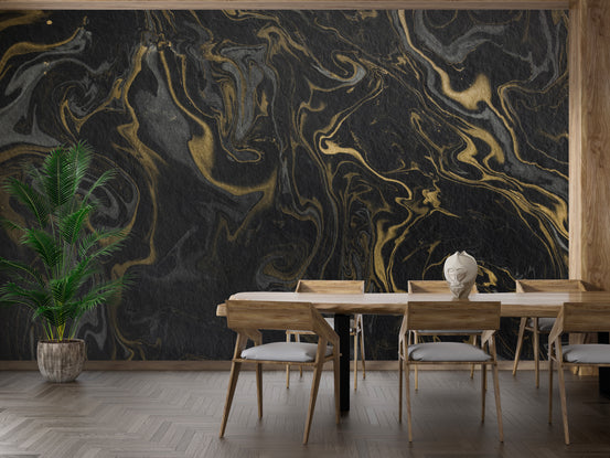 Black and Gold Marble Effect wallpaper mural with swirling gold veins behind a wood dining table and potted palm