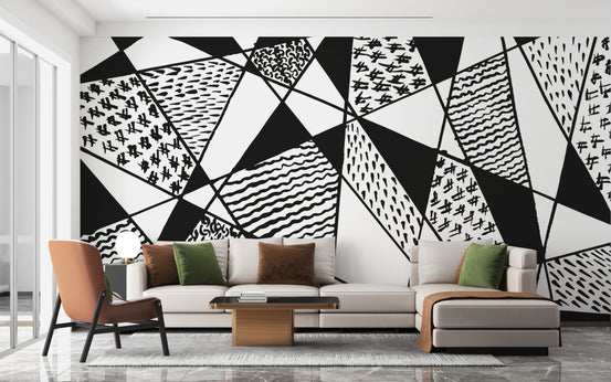 Black and white stroke line wallpaper mural of patterned geometric triangles behind a cream sectional sofa