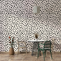 Hand-drawn black ink spots on cream wallpaper for a nursery.
