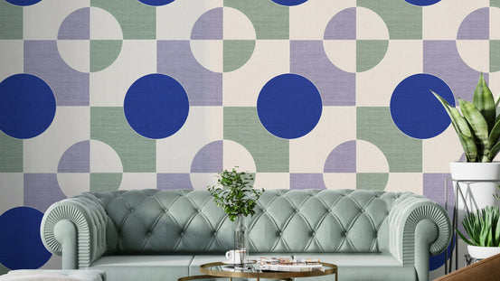 Blue Circle Canvas wallpaper mural with cobalt circles on a sage grid behind a sage tufted sofa