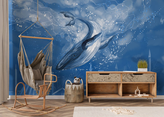 Blue Whale wallpaper mural with a leaping whale in deep blue behind a hanging hammock chair and wooden console