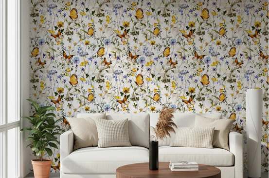 Butterfly Meadow wallpaper mural in a living room with a cream sofa, woven cushions and round wooden table