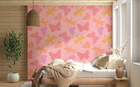 Whimsical wallpaper mural with stylized butterflies and dragonflies in shades of yellow, coral, and lavender.