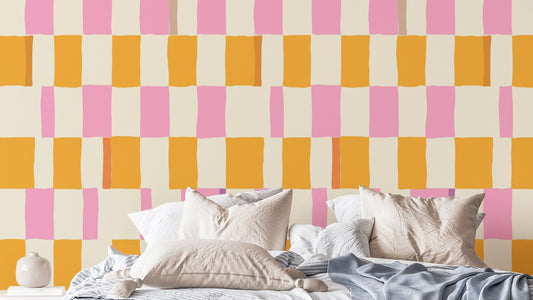 Colorful Checkered wallpaper with hand-painted pink and orange squares above a bed with white pillows