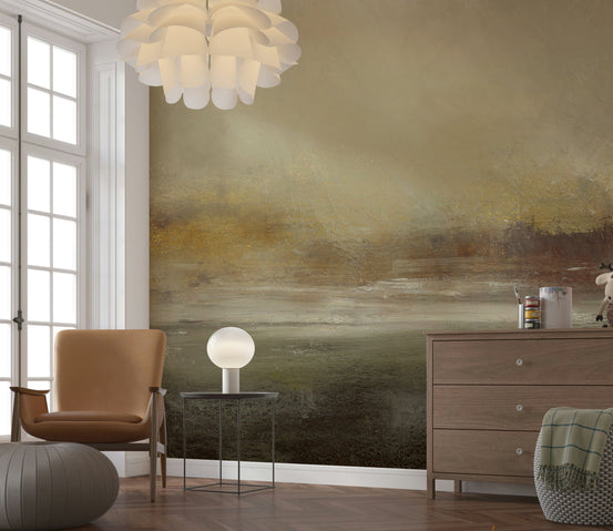 Abstract Horizon wallpaper mural in olive and amber behind a tan leather armchair and globe lamp in a living room