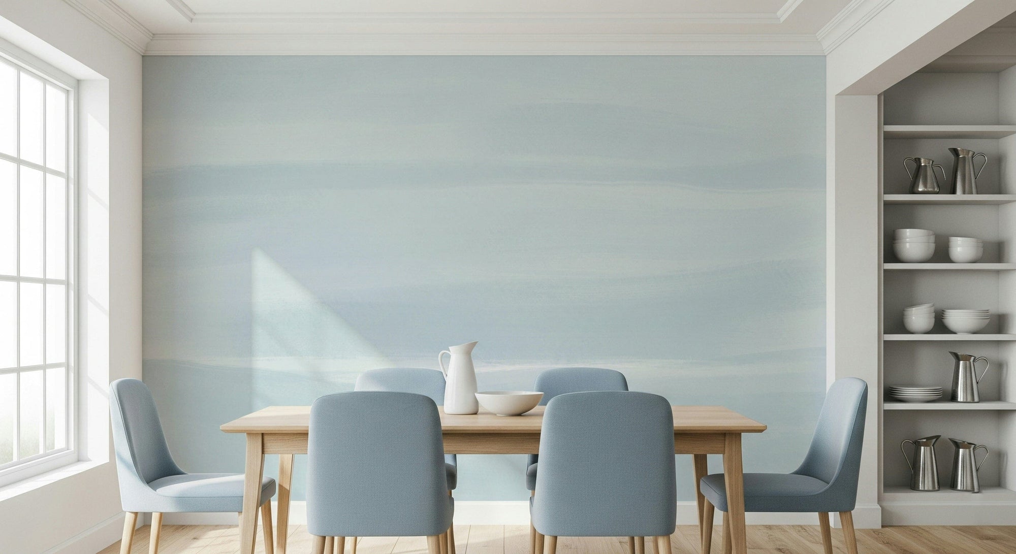 Serene Sky wallpaper mural of soft blue watercolor haze behind a wood dining table and dusty blue chairs