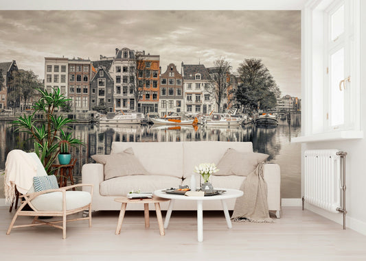 Canal Harmony wallpaper mural of a sepia Amsterdam canal behind a cream sofa and rattan chair in a bright living room