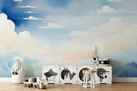 Blue sky mural with soft white clouds in a spacious studio apartment.