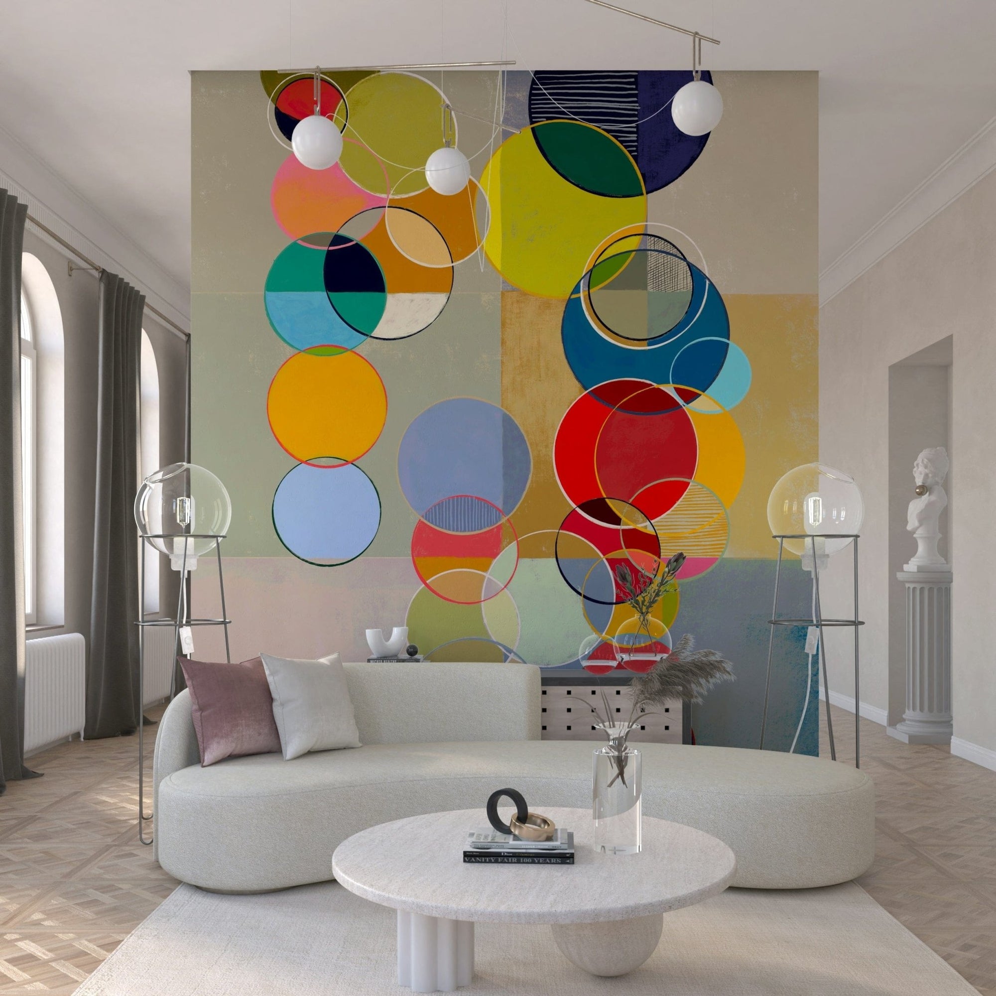 Chromatic Circles wallpaper mural of overlapping bright circles behind a cream curved sofa and globe floor lamps