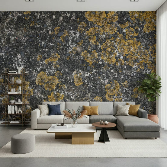 Cracked Stone wallpaper mural of grey rock with gold lichen behind a grey sectional sofa and bookshelf