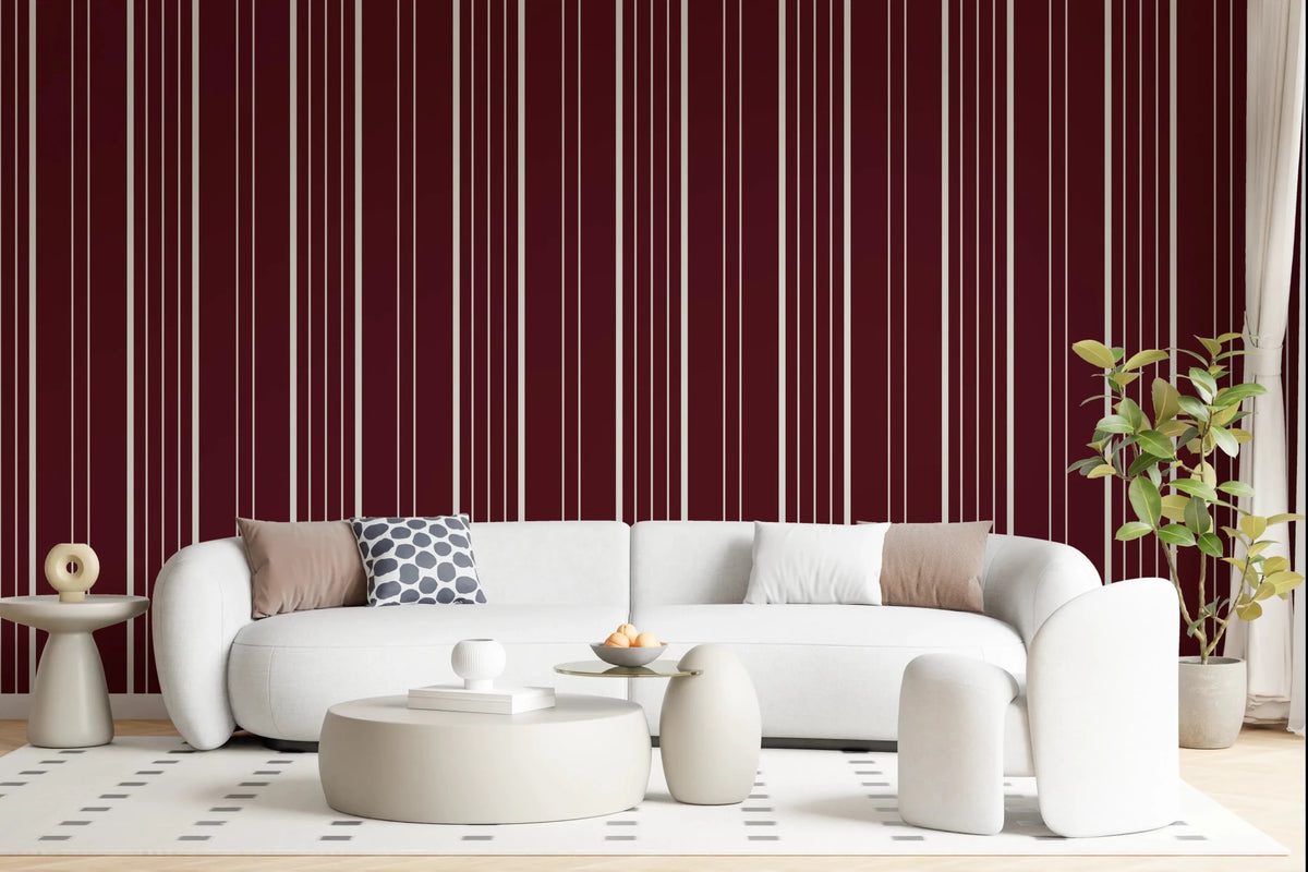 Crimson Stripes wallpaper in a living room with a white curved sofa, round tables and rubber plant