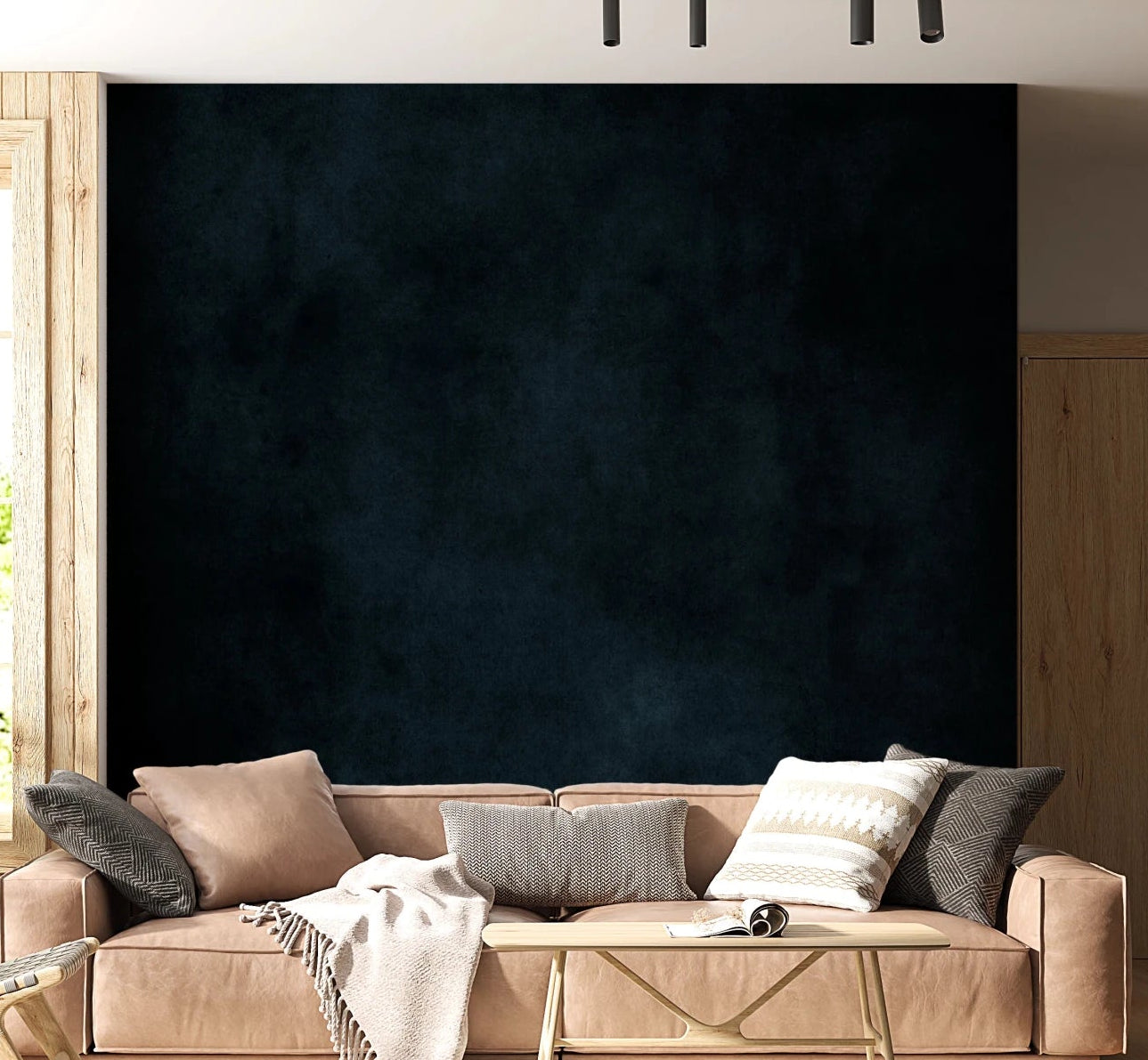 Dirty Paper Midnight wall mural in dark navy plaster behind a tan leather sofa with knit throw in a living room