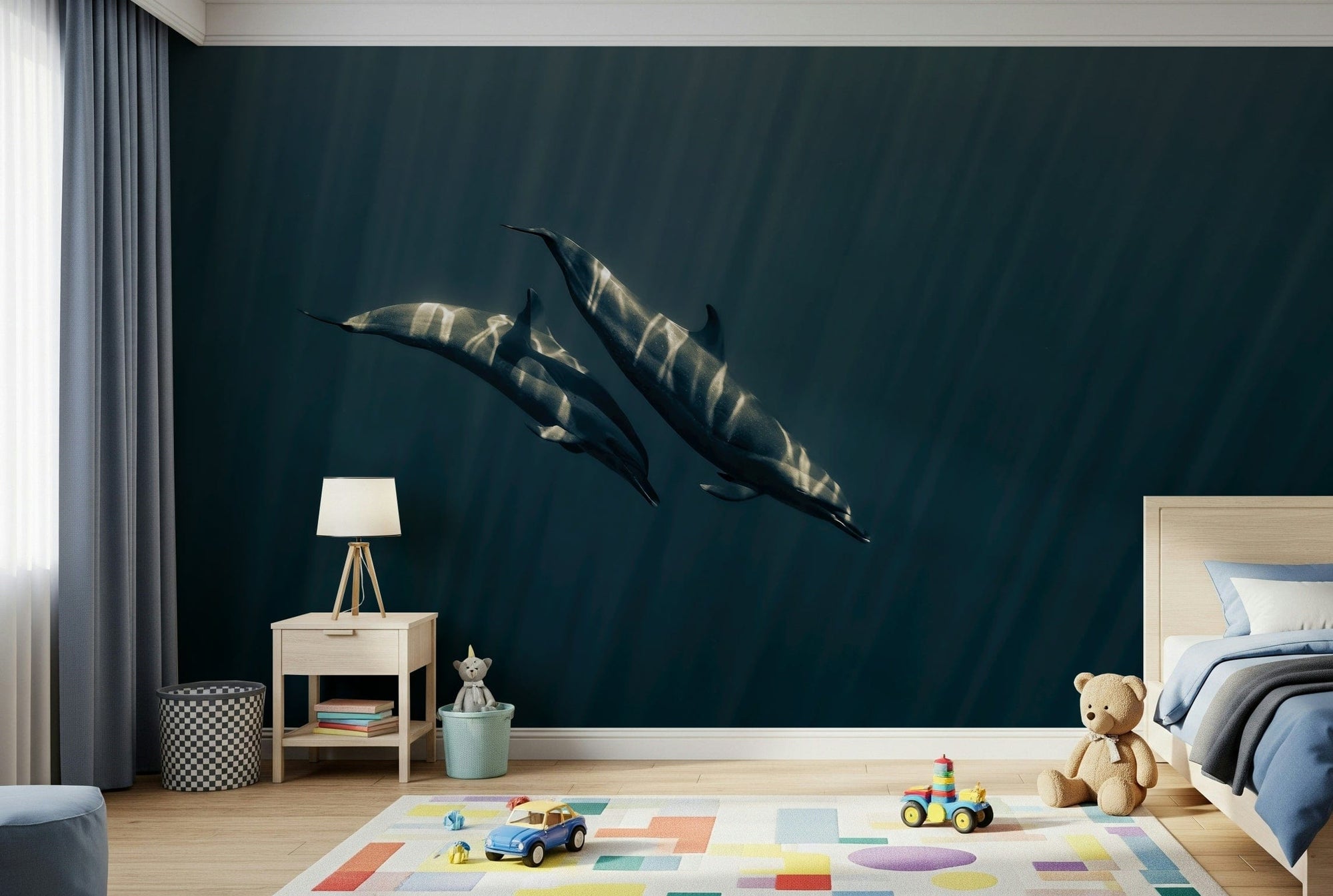 Deep Blue Journey wallpaper mural of two dolphins gliding through deep blue ocean above a light wood bed and play rug in a kids room