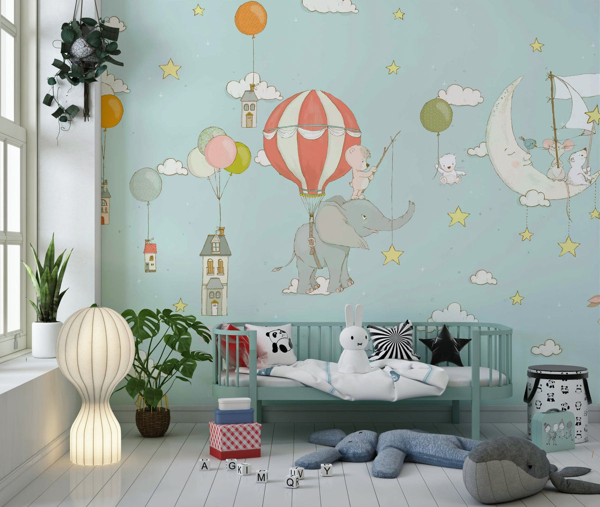 Dreamy Sky Tales wallpaper mural with elephant and balloon behind a mint daybed with panda and whale plush