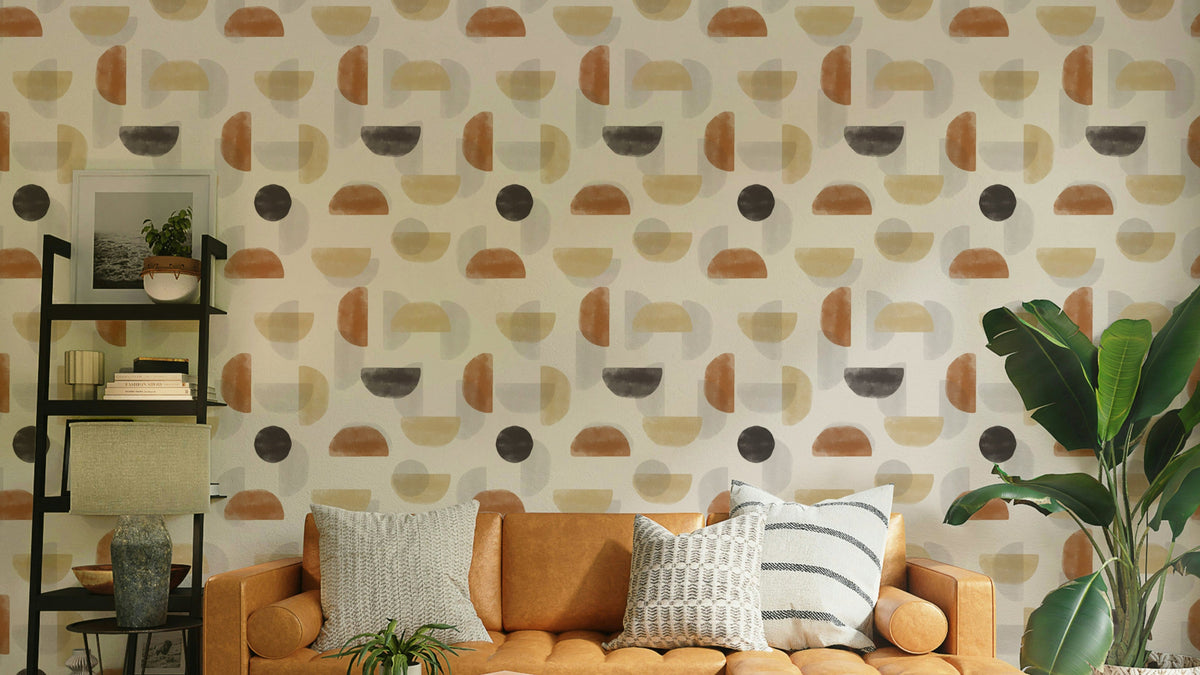 Earthy Hues Abstract wallpaper behind a tan leather sofa with a black shelf in a warm living room