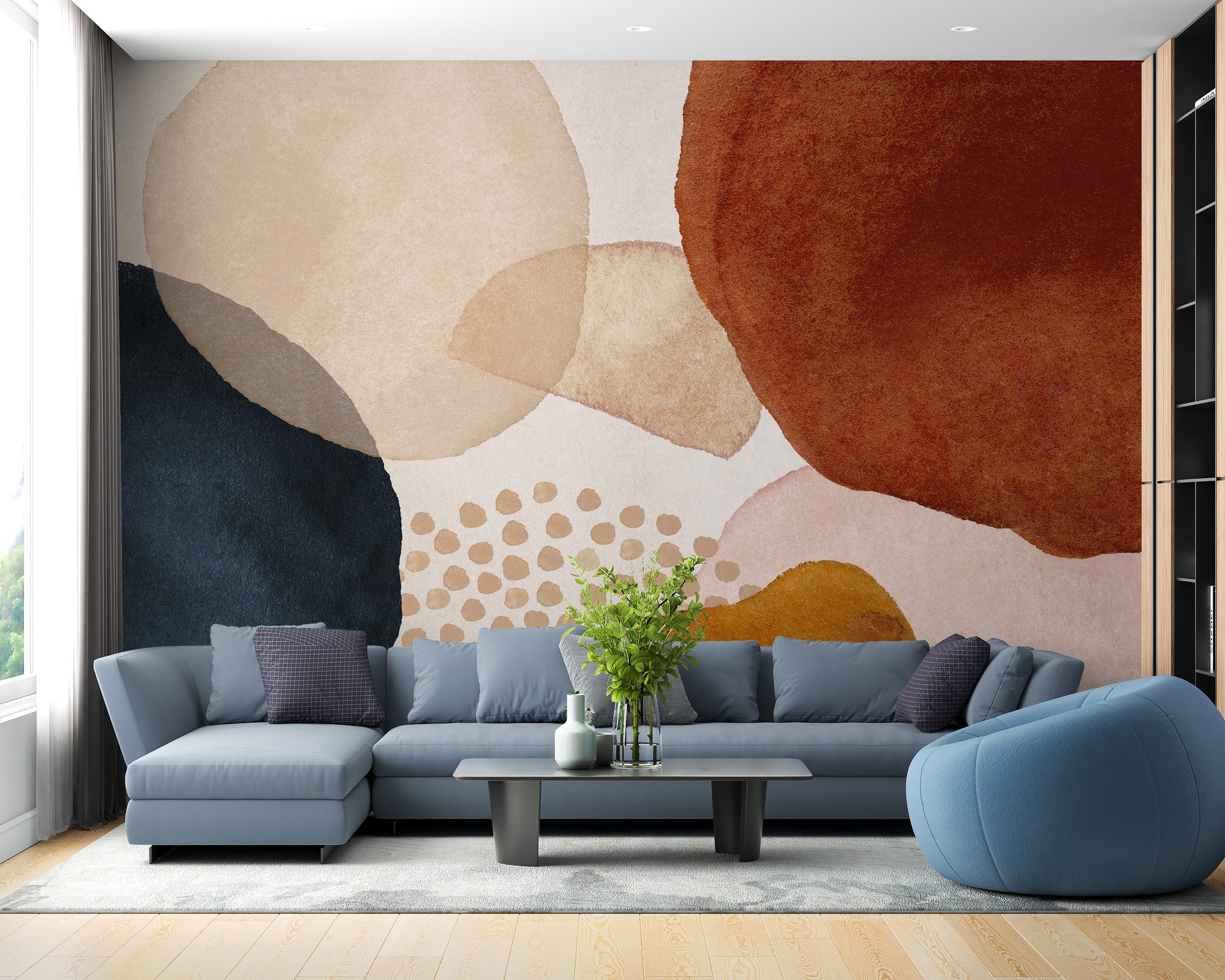 Boho Abstract Geometric wallpaper mural in navy, terracotta and beige behind a blue sectional sofa and armchair in a living room