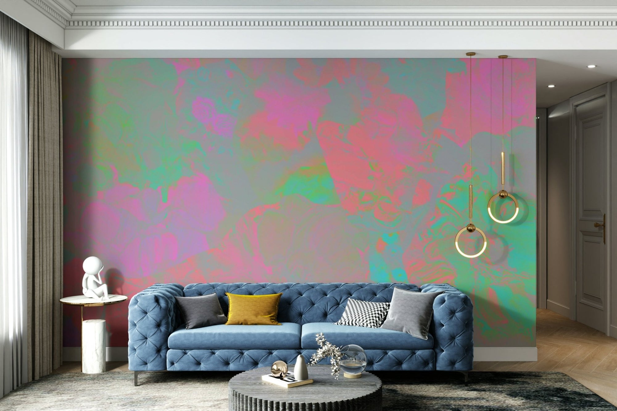 Ephemeral Bloom wallpaper mural with iridescent pink and green abstract bloom behind a blue tufted Chesterfield sofa in a living room
