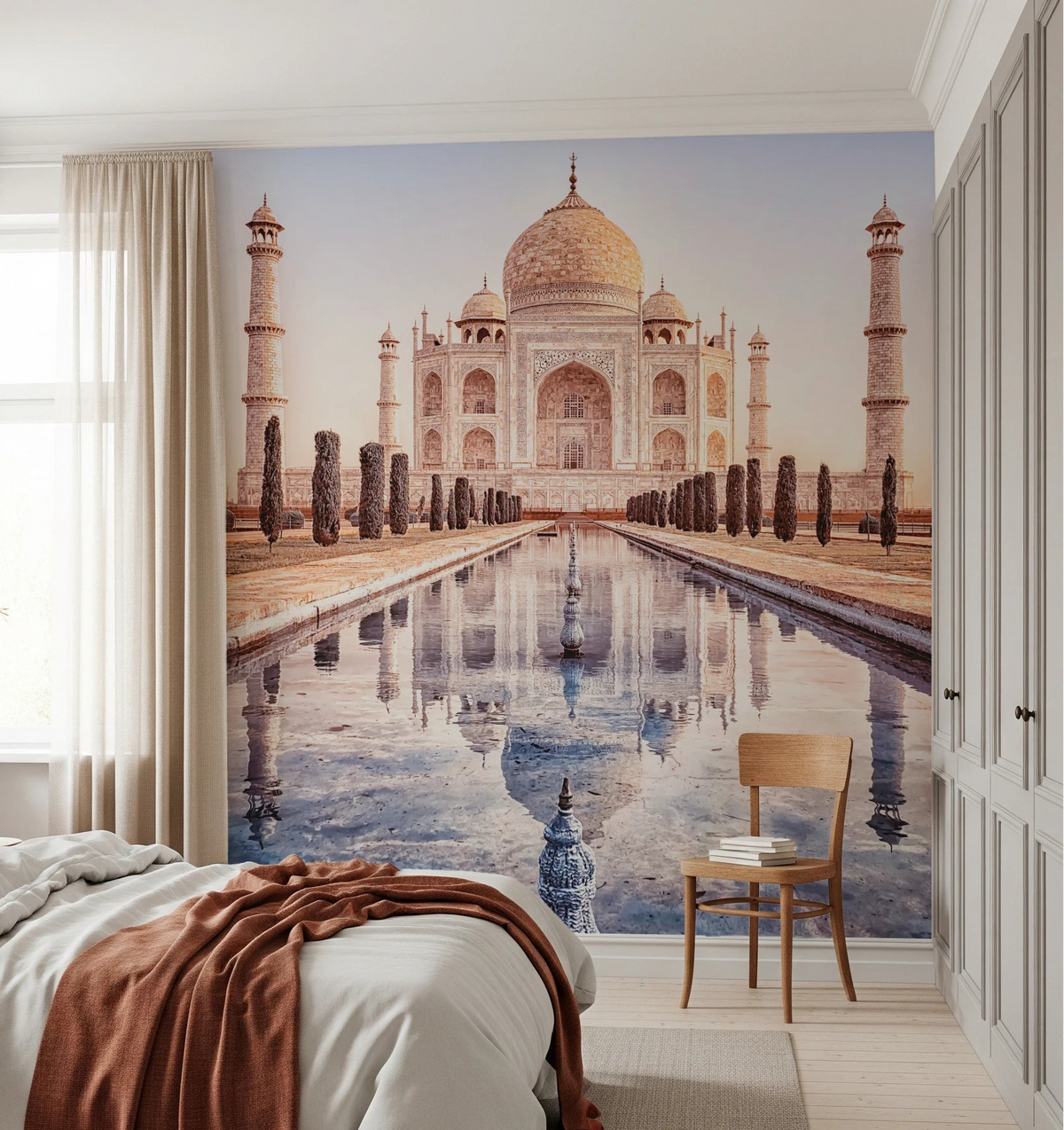 Eternal Taj wallpaper mural of the Taj Mahal and reflecting pool behind a bed and wood chair in a bedroom