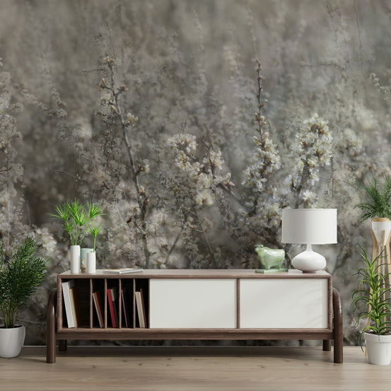Ethereal Blossoms soft floral photography wall mural behind a wood mid-century sideboard with books and a white lamp in a living room