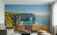 Yellow bloom wall mural on rocky coast, balanced green color details and ocean wallpaper backdrop