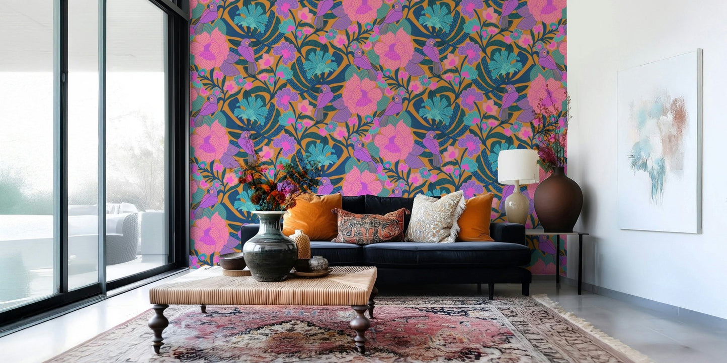 Exotic Bloom wallpaper behind a navy sofa with orange pillows and an ottoman table on a faded pink rug