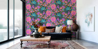 Exotic Bloom wallpaper behind a navy sofa with orange pillows and an ottoman table on a faded pink rug